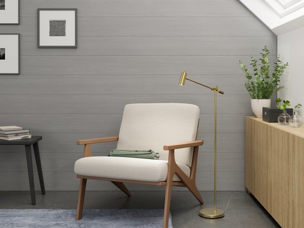 Cato Golvlampa blankslipad mässing vid en fåtölj